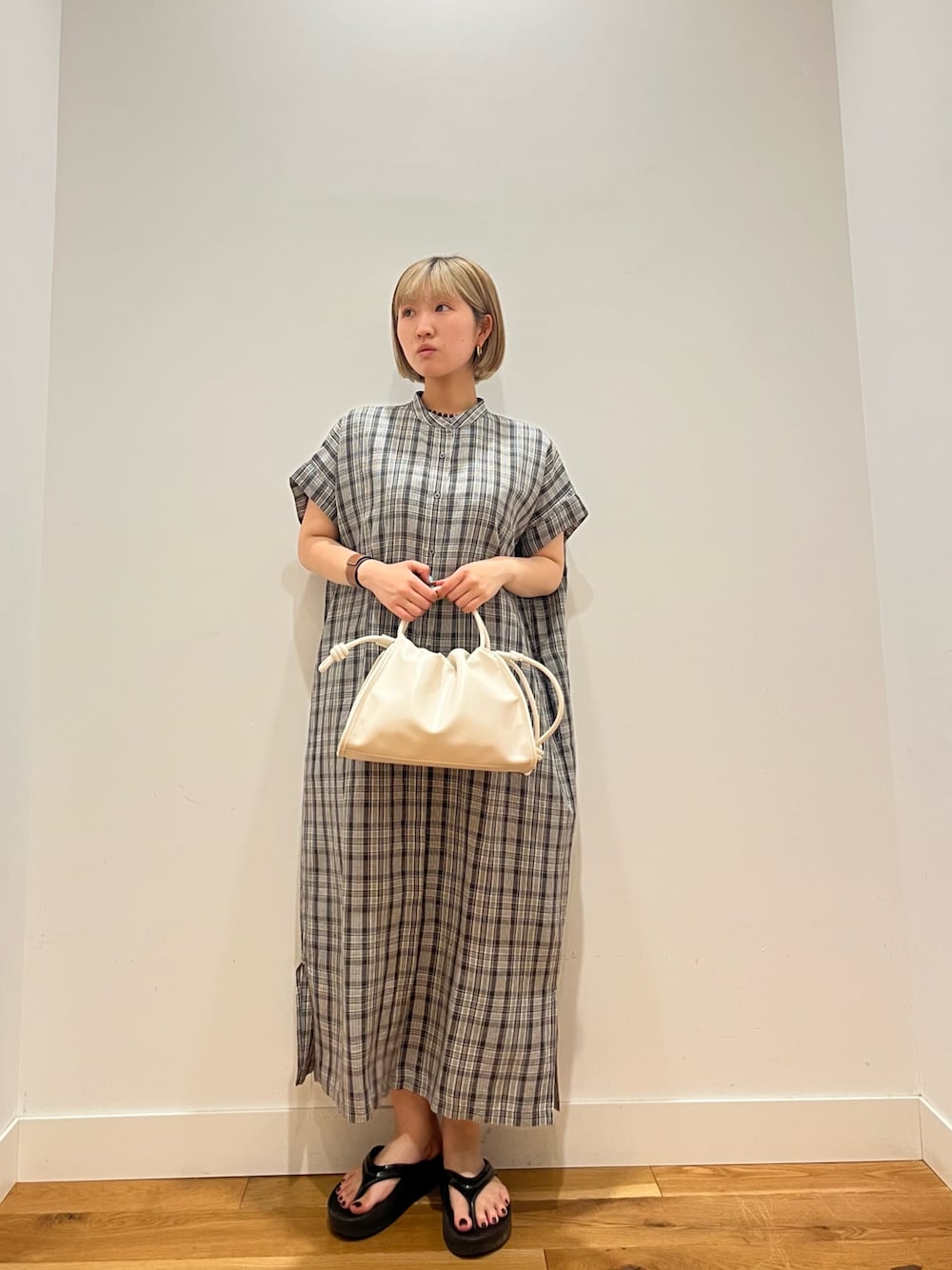 グレー系のワンピース、ブルー系のネックレスを着用したレディースの夏コーディネートの1枚目の写真