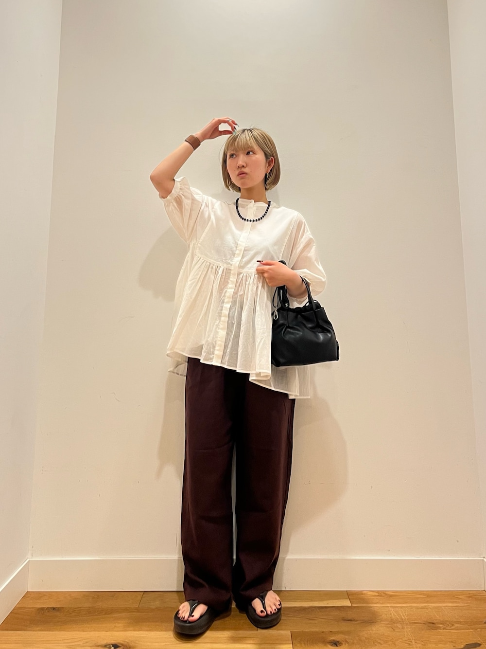 レッド系のその他パンツ、グレー系のシャツ/ブラウス、ブルー系のネックレスを着用したレディースの夏コーディネートの1枚目の写真