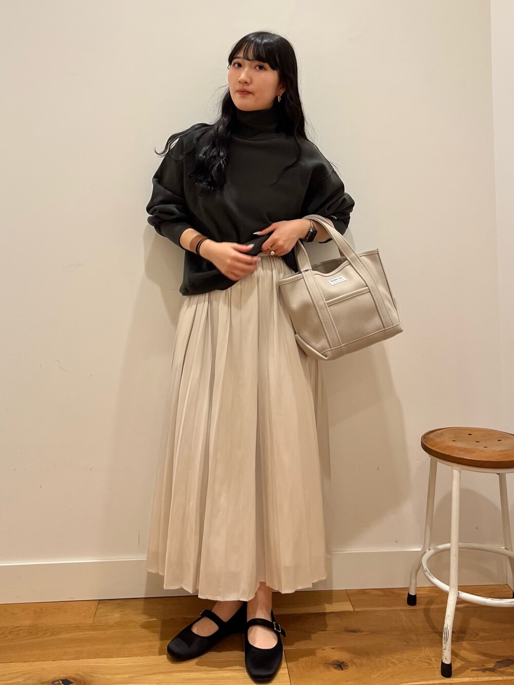 ブラック系のスウェット、ブラウン系のスカート、ベージュ系のトートバッグを着用したレディースの秋コーディネートの1枚目の写真