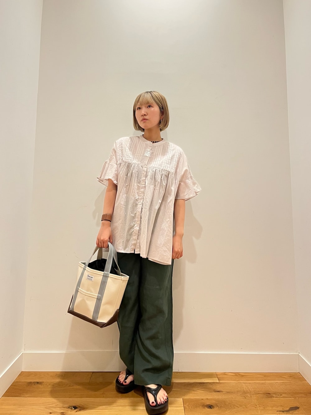 グレー系のシャツ/ブラウス、グリーン系のその他パンツ、グリーン系のトートバッグを着用したレディースの夏コーディネートの1枚目の写真