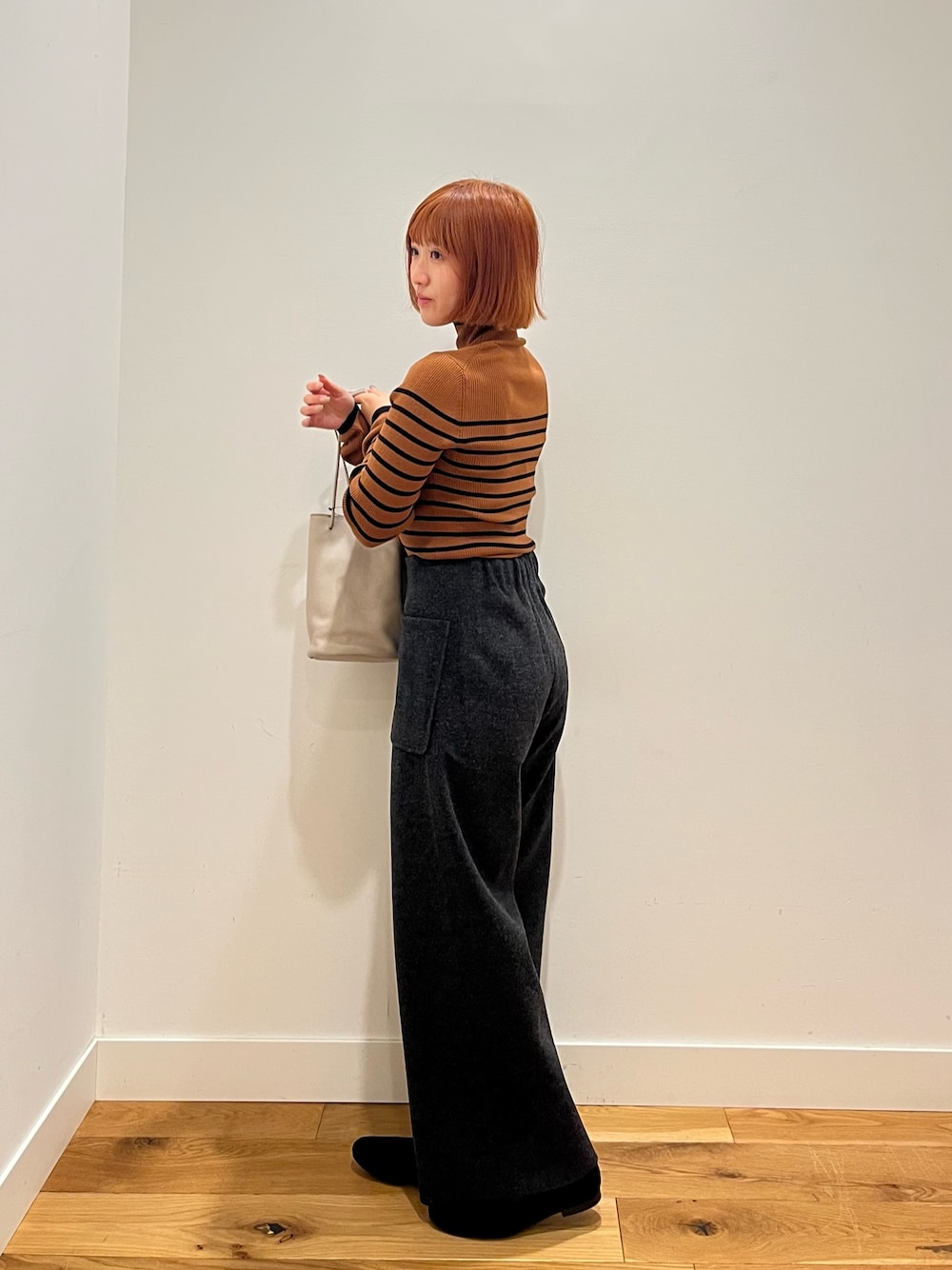 ブラウン系のニット/セーター、グレー系のその他パンツ、グレー系のショルダーバッグを着用したレディースの冬コーディネートの1枚目の写真