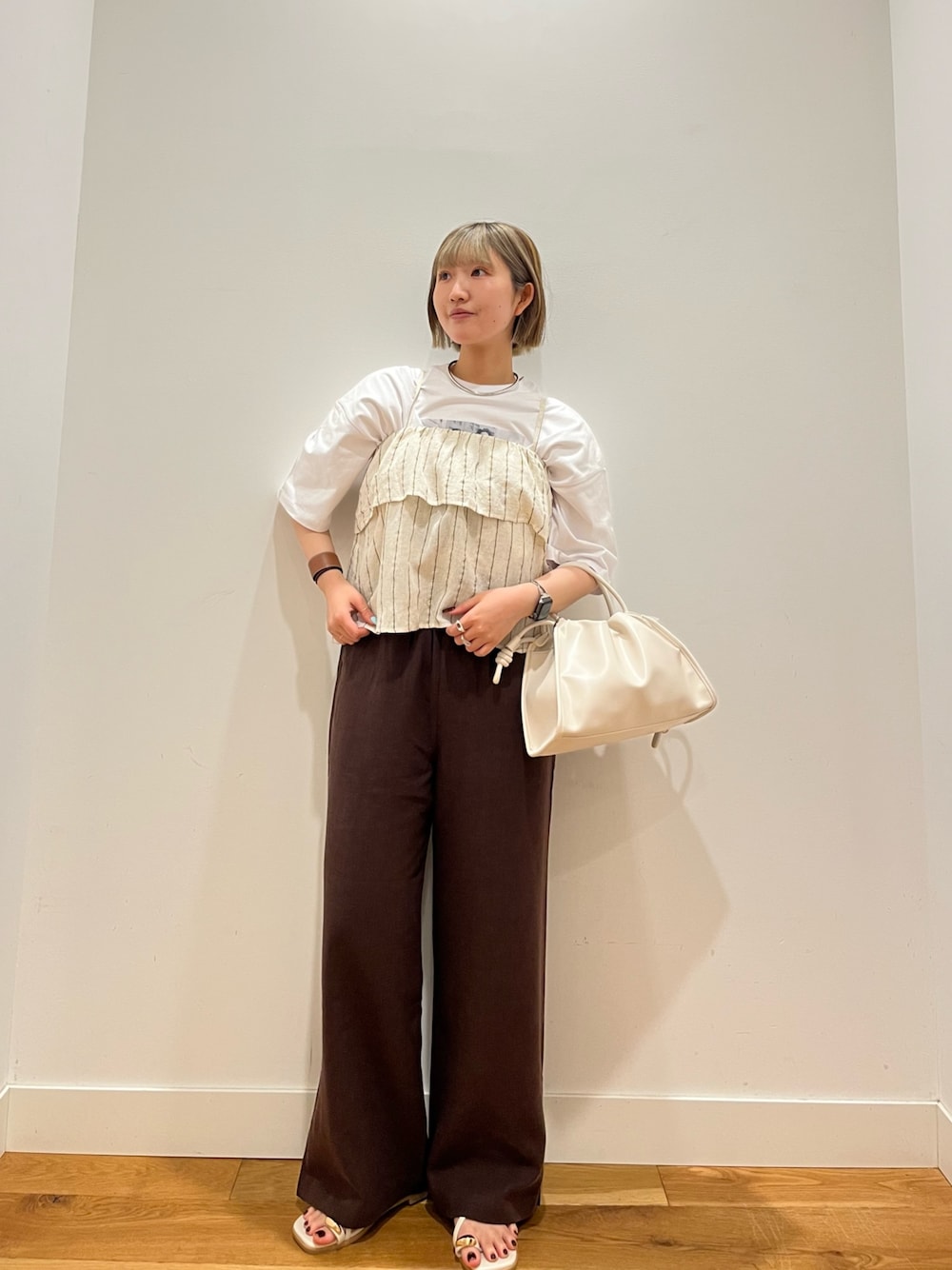 ホワイト系のトートバッグ、ホワイト系のTシャツ/カットソー、ベージュ系のワンピースを着用したレディースの春コーディネートの1枚目の写真