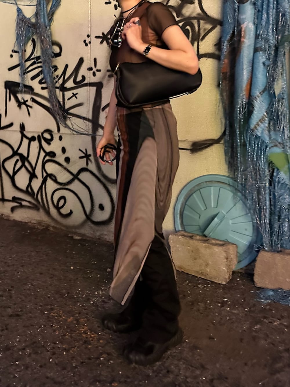 ブラック系のハンドバッグ、ブラック系のスニーカー、ブラック系のパンツを着用したレディースの秋コーディネートの1枚目の写真