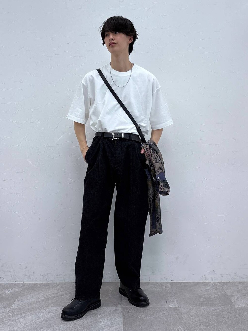 ブラック系のドレスシューズ、ブラック系のデニムパンツ、ホワイト系のTシャツ/カットソーを着用したメンズの春コーディネートの1枚目の写真
