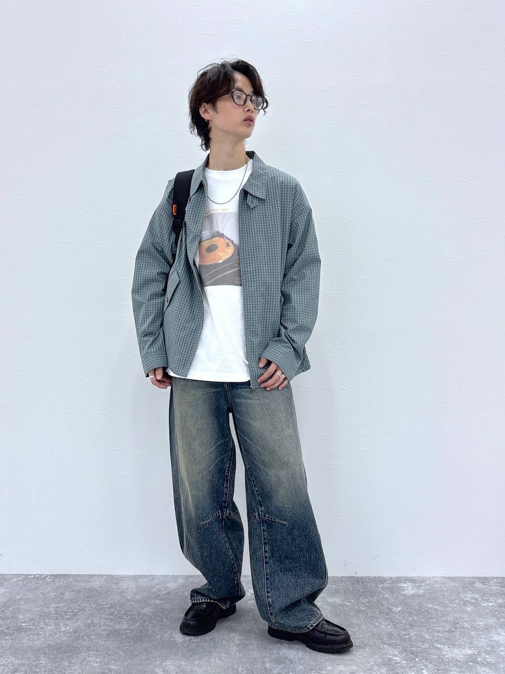 ブラック系のバックパック/リュック、ブルー系のデニムパンツ、ホワイト系のTシャツ/カットソーを着用したメンズの秋コーディネートの1枚目の写真