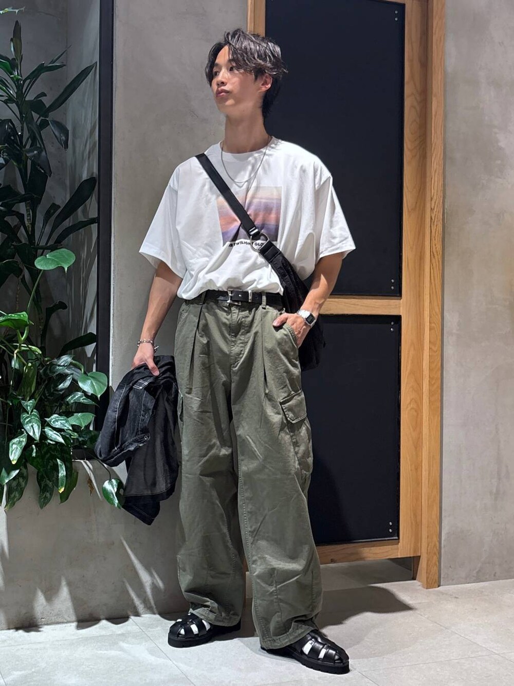 グリーン系のカーゴパンツ、ブラック系のサンダル、ブラック系のシャツ/ブラウスを着用したメンズの夏コーディネートの1枚目の写真
