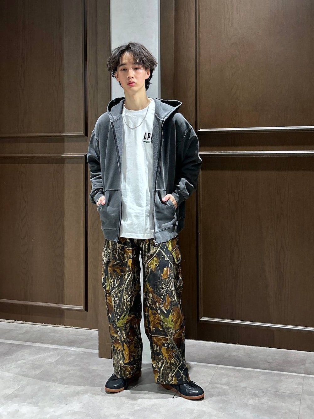 ブラック系のパーカー、ホワイト系のTシャツ/カットソー、ブラック系のスニーカーを着用したメンズの春コーディネートの1枚目の写真