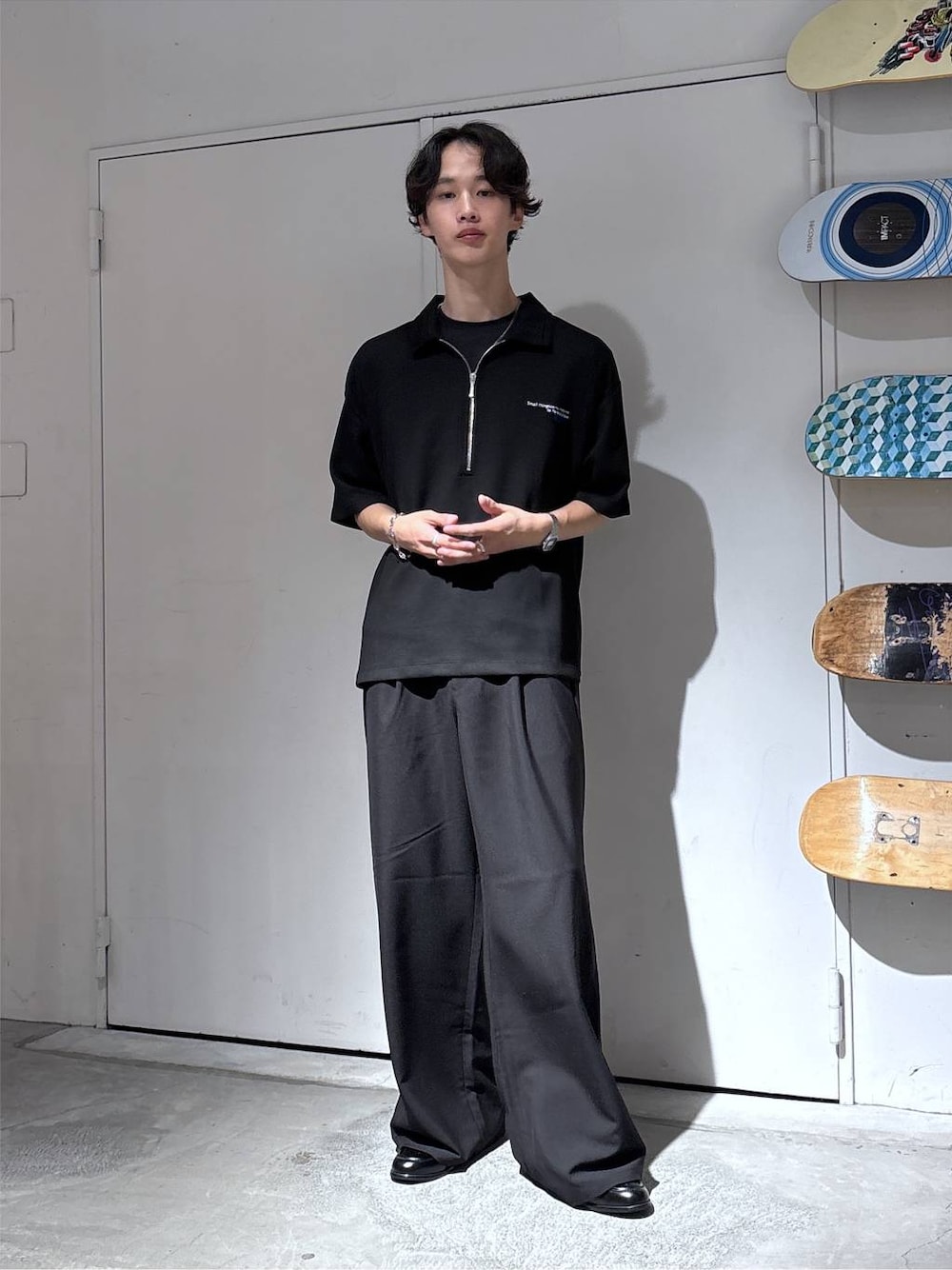 ブラック系のTシャツ/カットソー、ブラック系のローファー、ブラック系のスラックスを着用したメンズの夏コーディネートの1枚目の写真