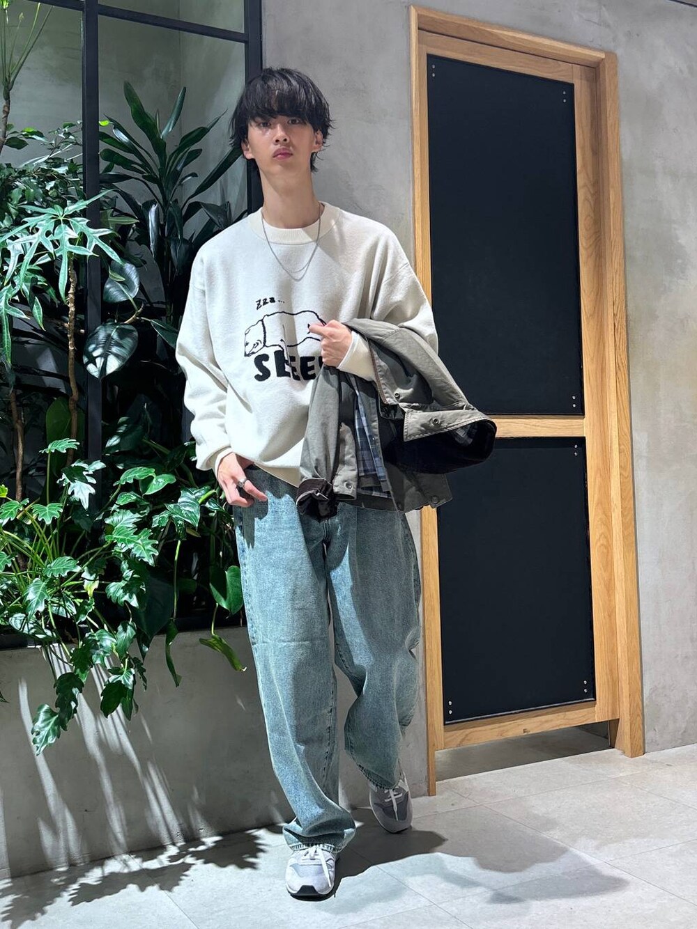 グレー系のスニーカー、ブルー系のデニムパンツ、グリーン系のブルゾンを着用したメンズの秋コーディネートの1枚目の写真