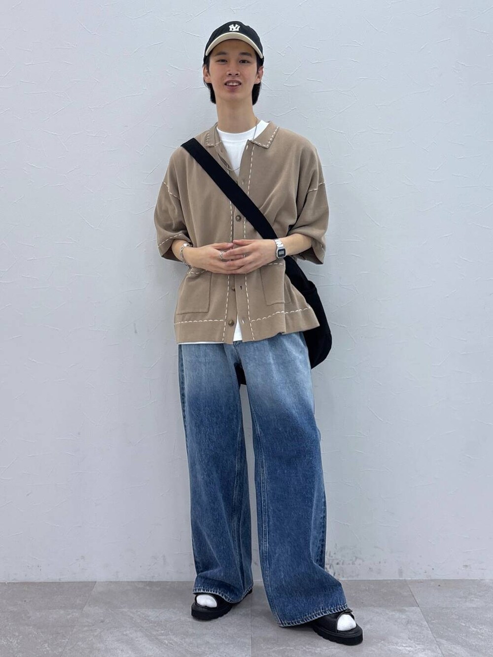ブルー系のデニムパンツ、ベージュ系のカーディガン/ボレロ、ブラック系のサンダルを着用したメンズの夏コーディネートの1枚目の写真