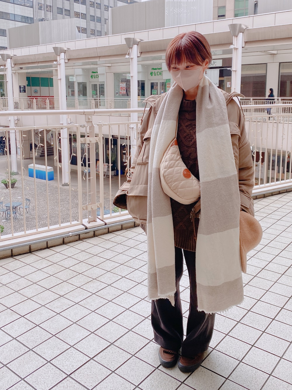 ブラウン系のパンツ、ベージュ系のショルダーバッグ、ベージュ系のジャケット/アウターを着用したレディースの冬コーディネートの1枚目の写真