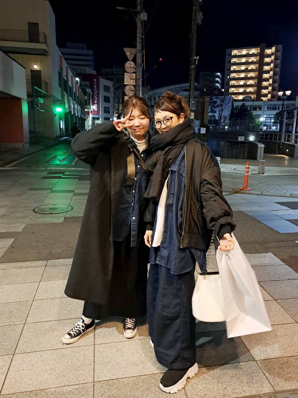 ブラック系のスカート、ホワイト系のTシャツ/カットソー、ブラック系のブーツを着用したレディースの冬コーディネートの1枚目の写真