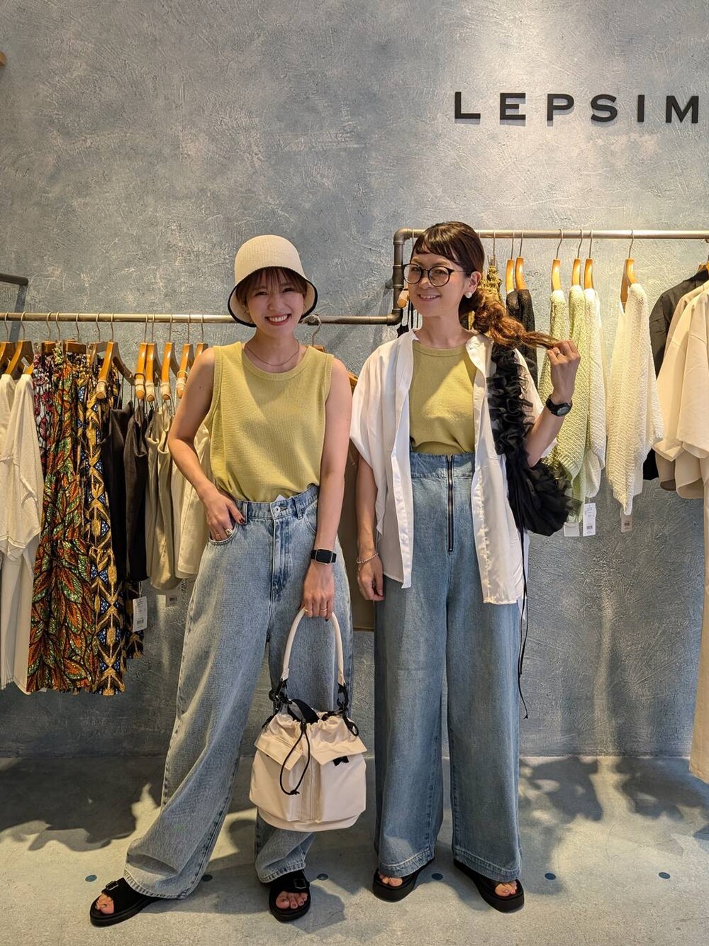 ブルー系のデニムパンツ、ホワイト系のショルダーバッグ、ホワイト系のシャツ/ブラウスを着用したレディースの夏コーディネートの1枚目の写真