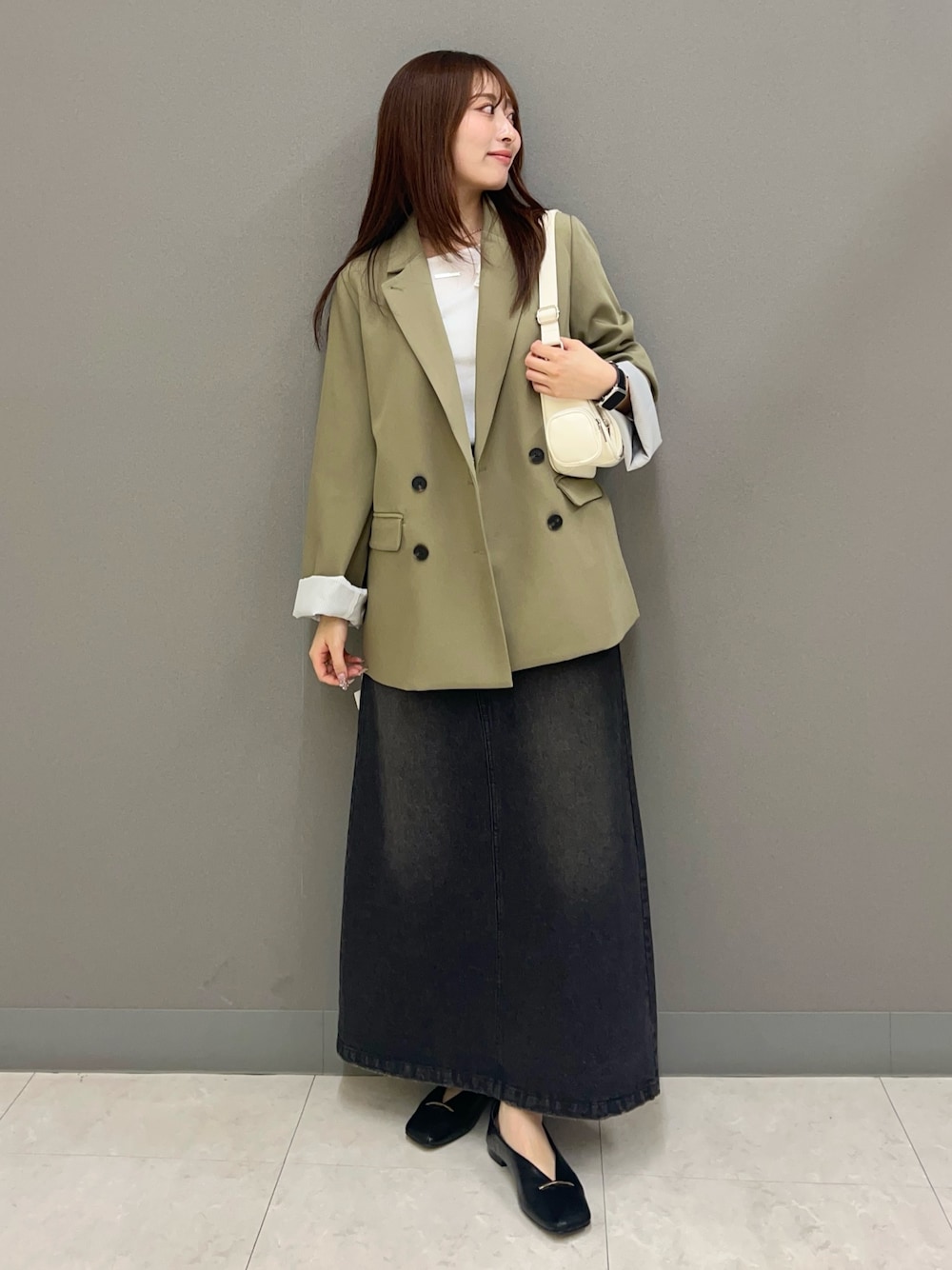 ホワイト系のショルダーバッグ、ブラック系のスカート、ホワイト系のTシャツ/カットソーを着用したレディースの冬コーディネートの1枚目の写真