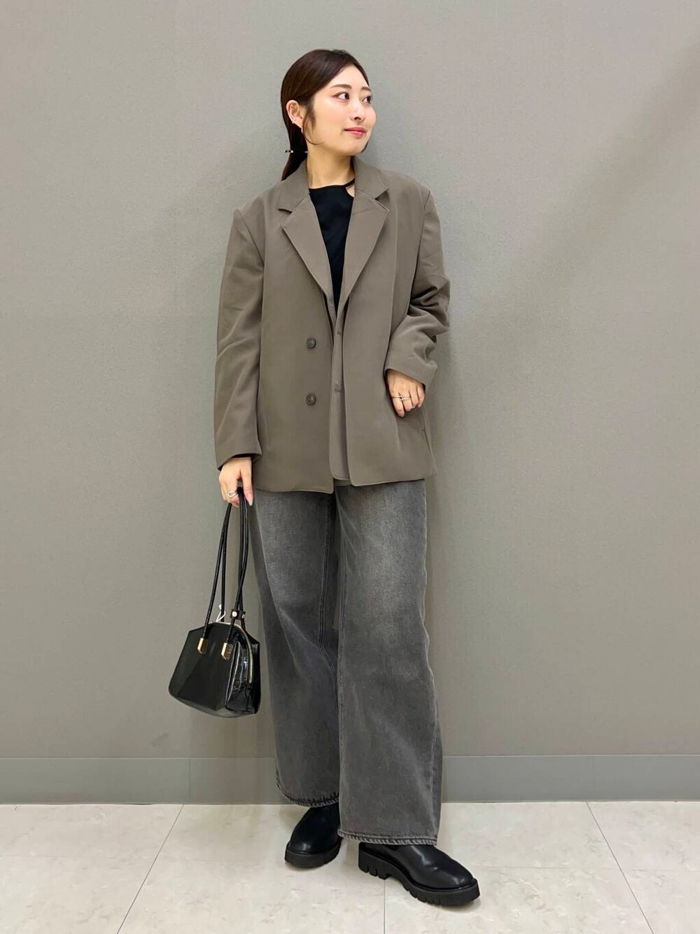 ブラック系のブーツ、グレー系のデニムパンツ、ブラウン系のテーラードジャケットを着用したレディースの秋コーディネートの1枚目の写真