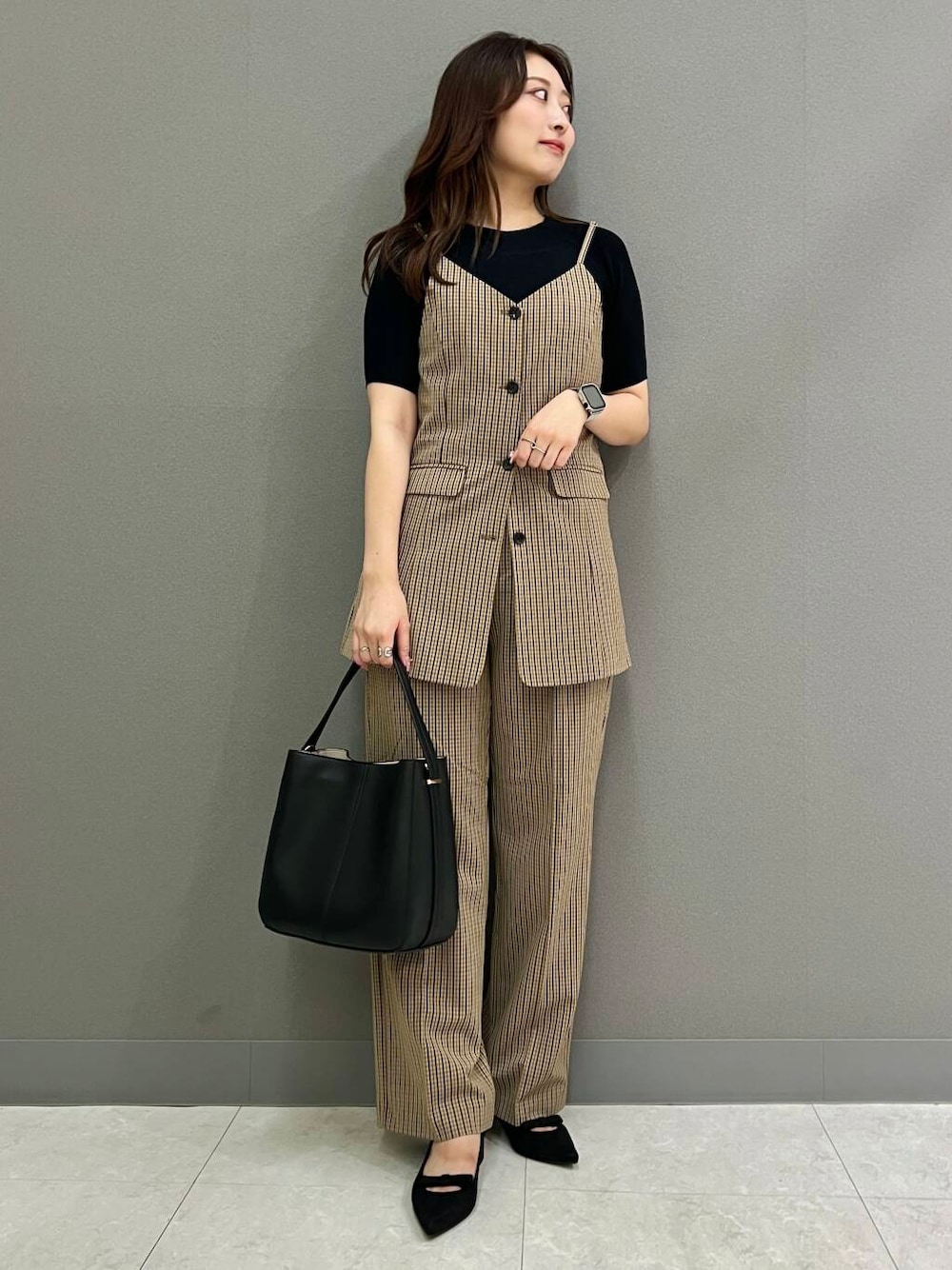 ブラック系のニット/セーター、ブラック系のハンドバッグ、ブラウン系のその他パンツを着用したレディースの夏コーディネートの1枚目の写真