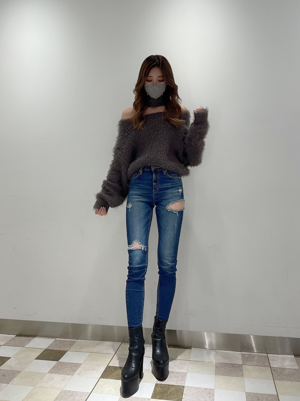 ブルー系のデニムパンツ、グレー系のニット/セーター、ブラック系のブーツを着用したレディースの冬コーディネートの1枚目の写真