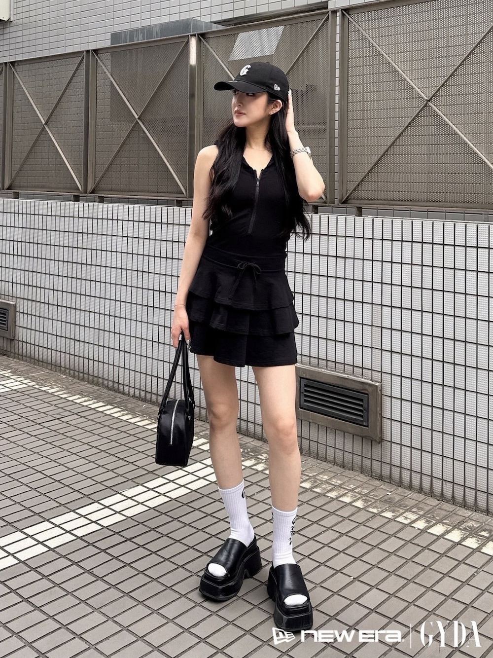 ブラック系のワンピース、ブラック系のボストンバッグ、ブラック系のキャップを着用したレディースの夏コーディネートの1枚目の写真