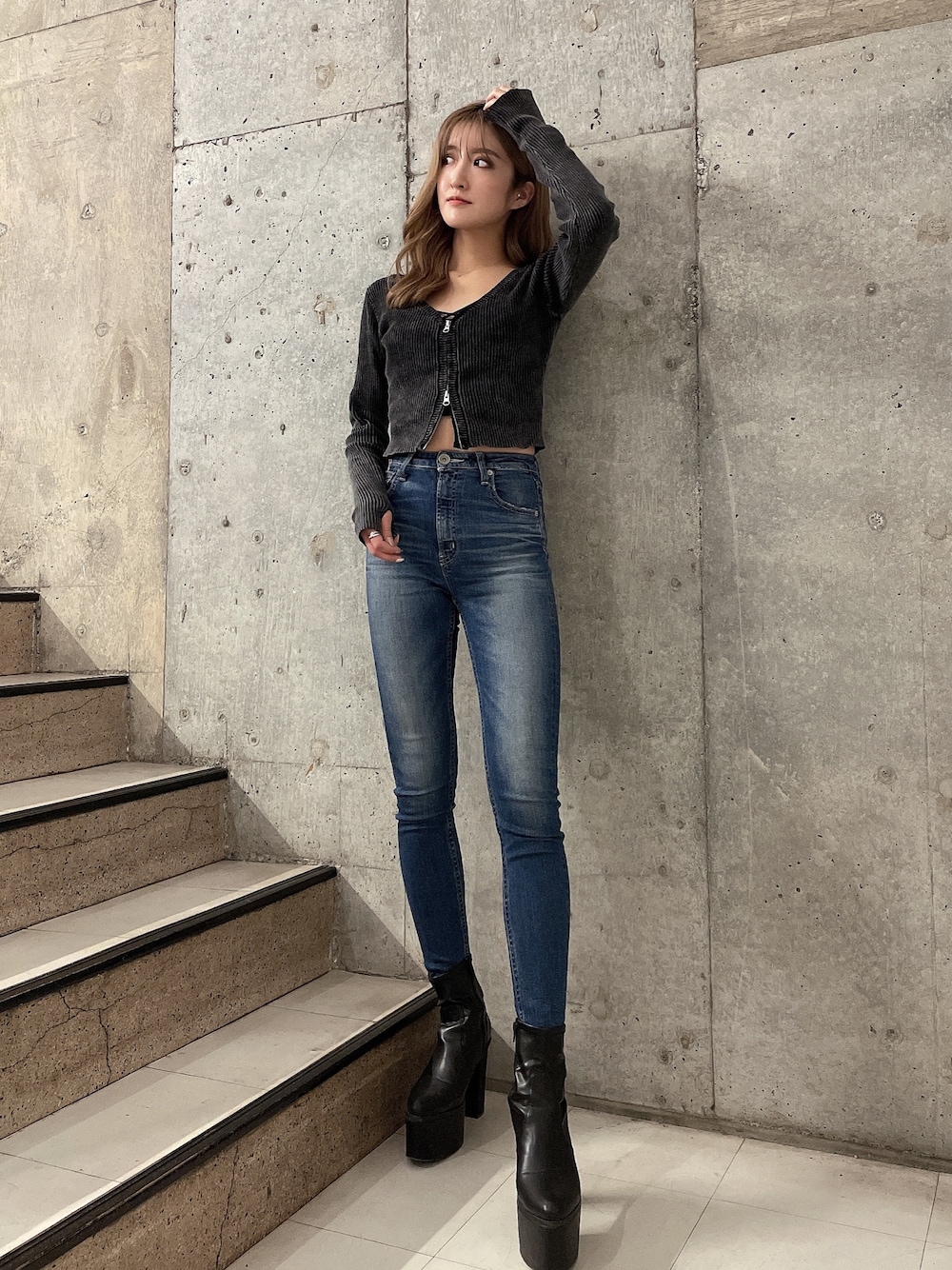 ブラック系のキャミソール、ブラック系のニット/セーター、ブルー系のデニムパンツを着用したレディースの秋コーディネートの1枚目の写真
