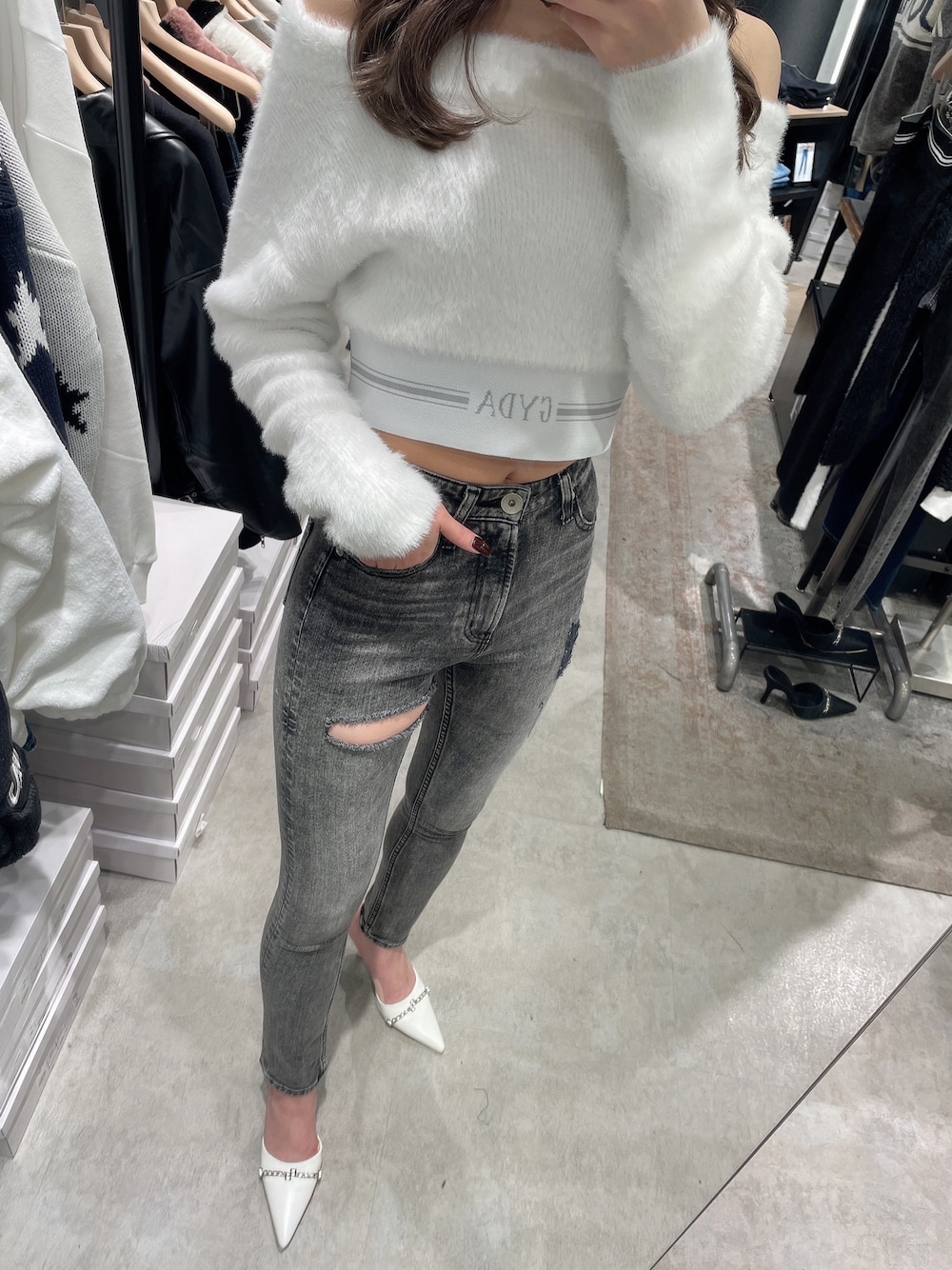 ホワイト系のニット/セーター、ホワイト系のパンプス、ブラック系のデニムパンツを着用したレディースの秋コーディネートの1枚目の写真