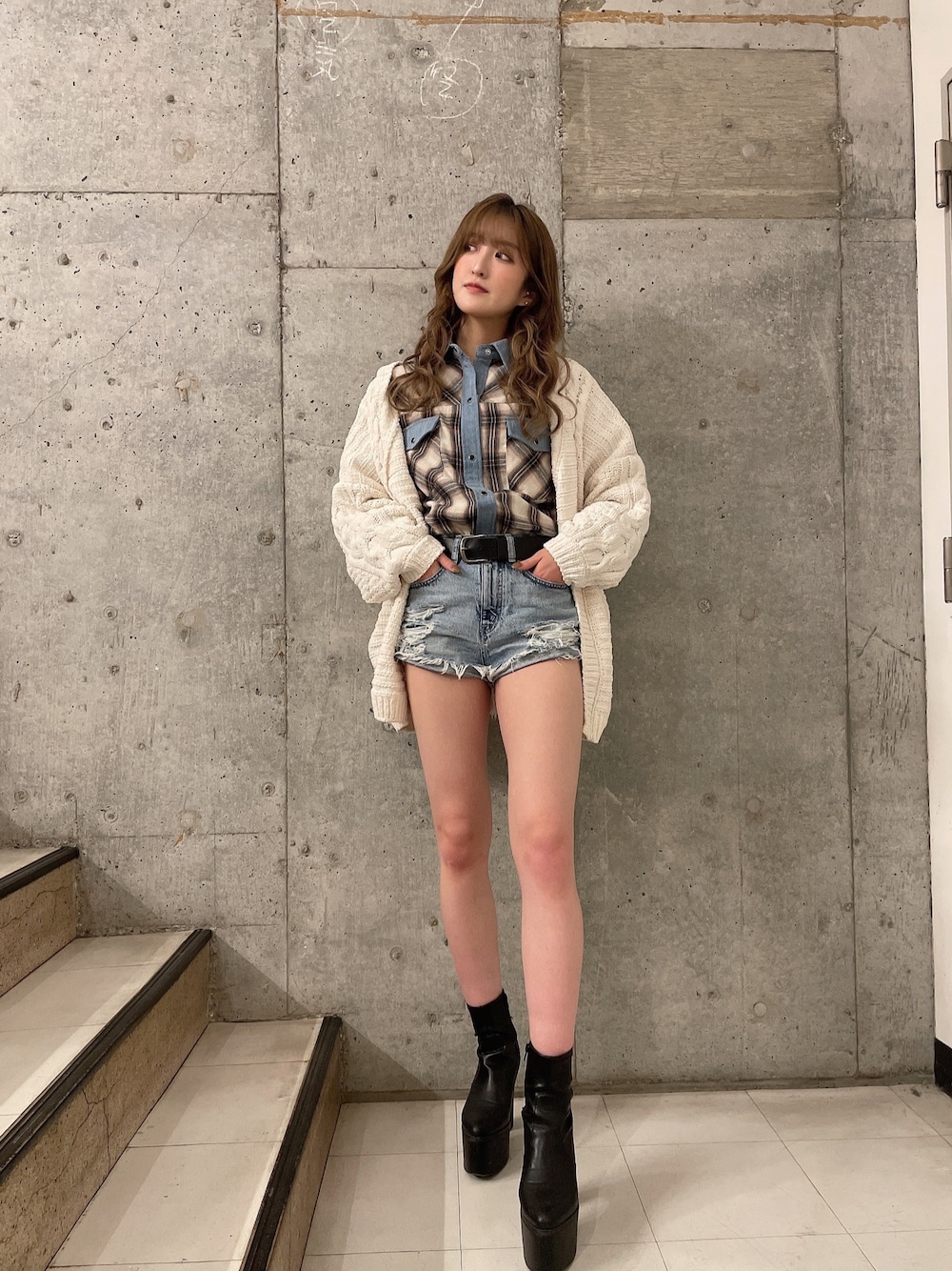 ホワイト系のカーディガン/ボレロ、ホワイト系のシャツ/ブラウス、ブラック系のブーツを着用したレディースの冬コーディネートの1枚目の写真