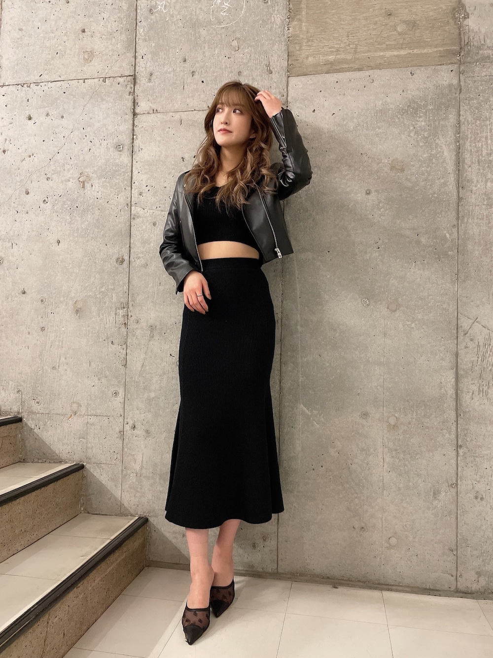 ブラック系のニット/セーター、ブラック系のスカート、ブラック系のライダースジャケットを着用したレディースの冬コーディネートの1枚目の写真