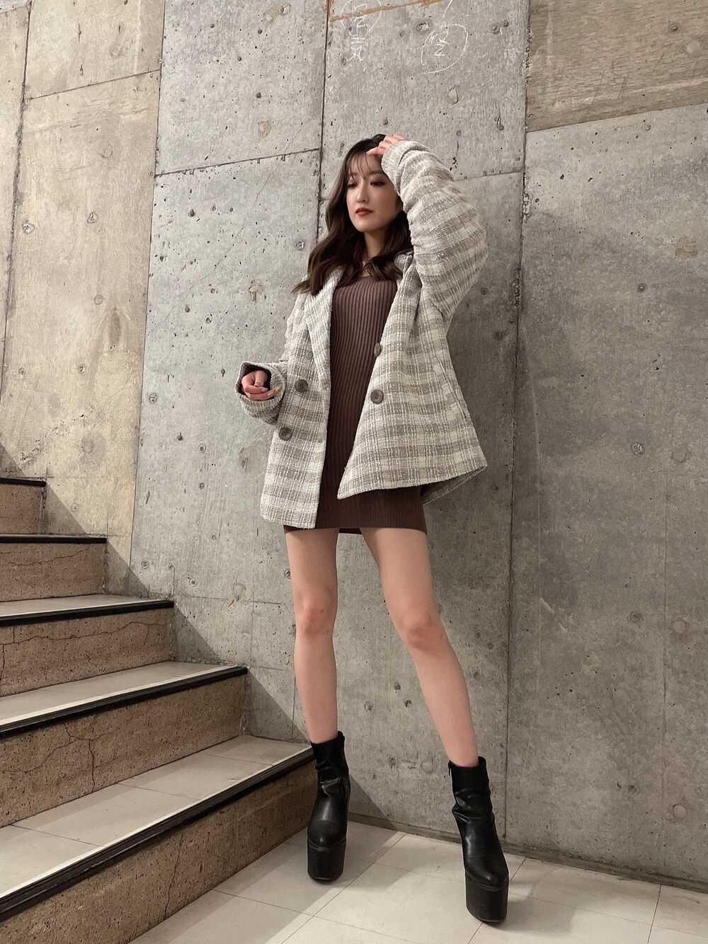 ベージュ系のワンピース、ブラック系のブーツ、ベージュ系のチェスターコートを着用したレディースの冬コーディネートの1枚目の写真