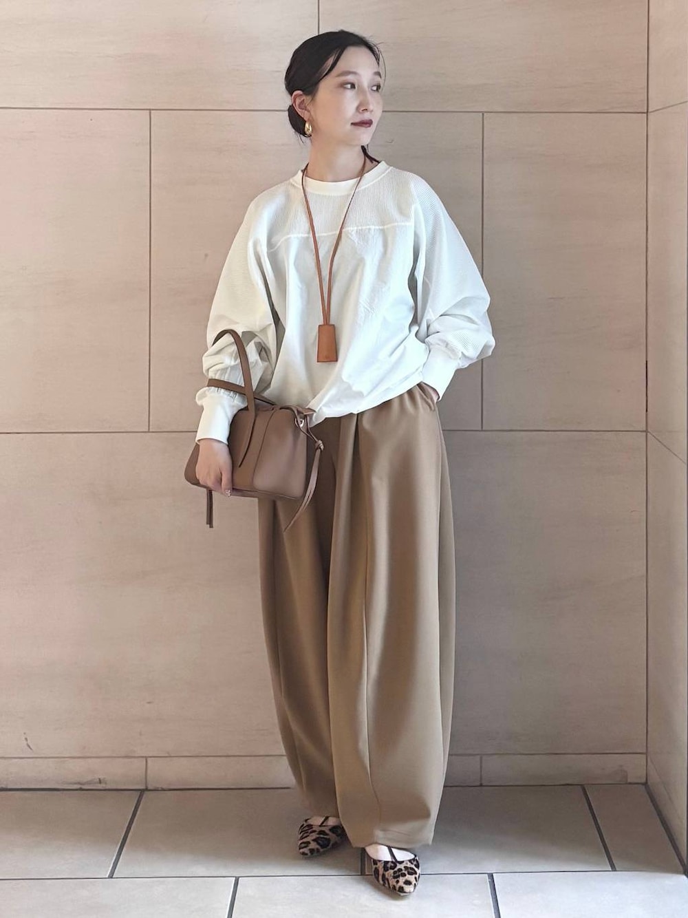 イエロー系のその他パンツ、ホワイト系のTシャツ/カットソー、ゴールド系のピアス(両耳用)を着用したレディースの冬コーディネートの1枚目の写真