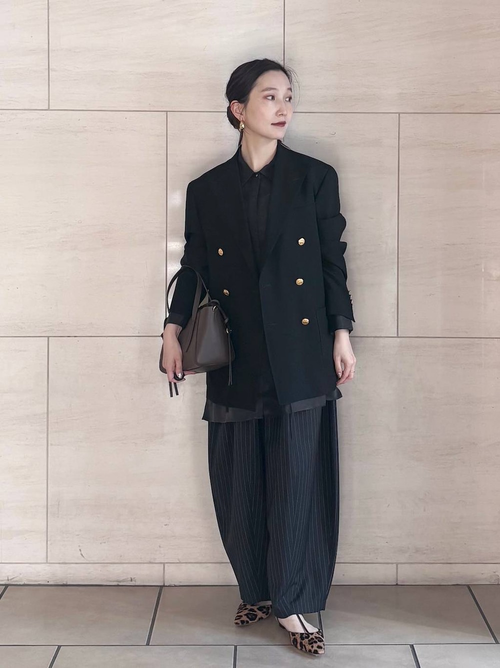 ブラック系のシャツ/ブラウス、ゴールド系のピアス(両耳用)を着用したレディースの冬コーディネートの1枚目の写真