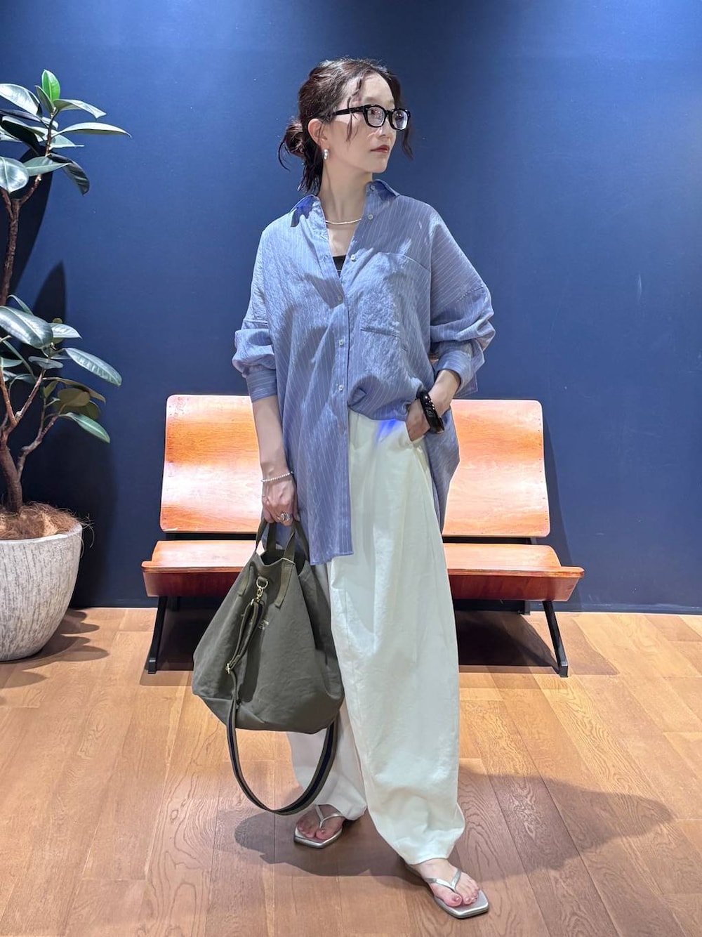 グリーン系のトートバッグ、ホワイト系のその他パンツ、ブルー系のシャツ/ブラウスを着用したレディースの夏コーディネートの1枚目の写真