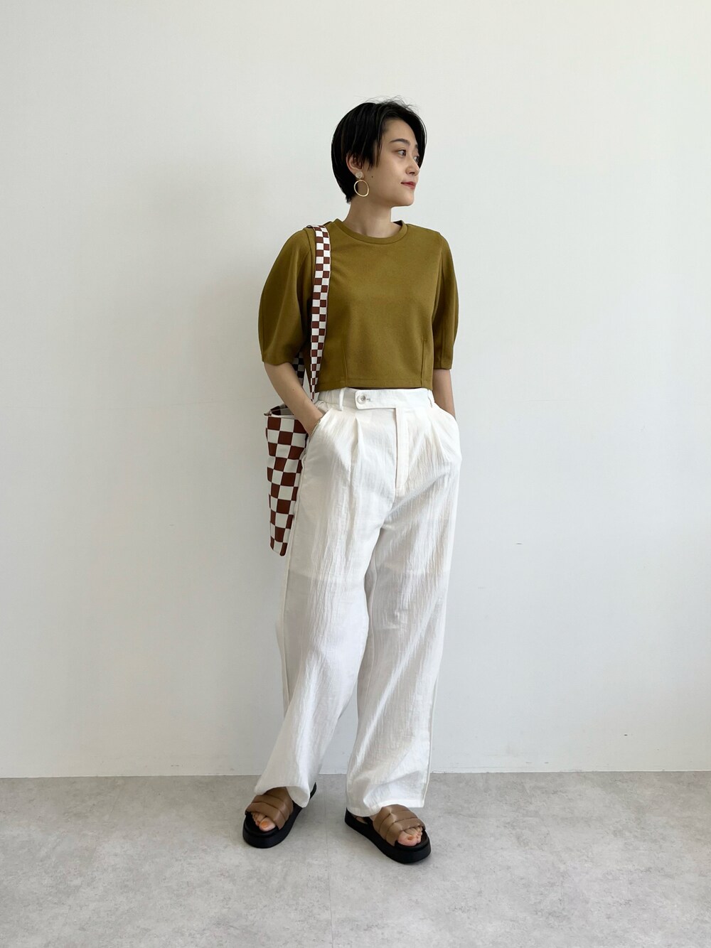 イエロー系のTシャツ/カットソー、ブラウン系のトートバッグ、ホワイト系のその他パンツを着用したレディースの春コーディネートの1枚目の写真