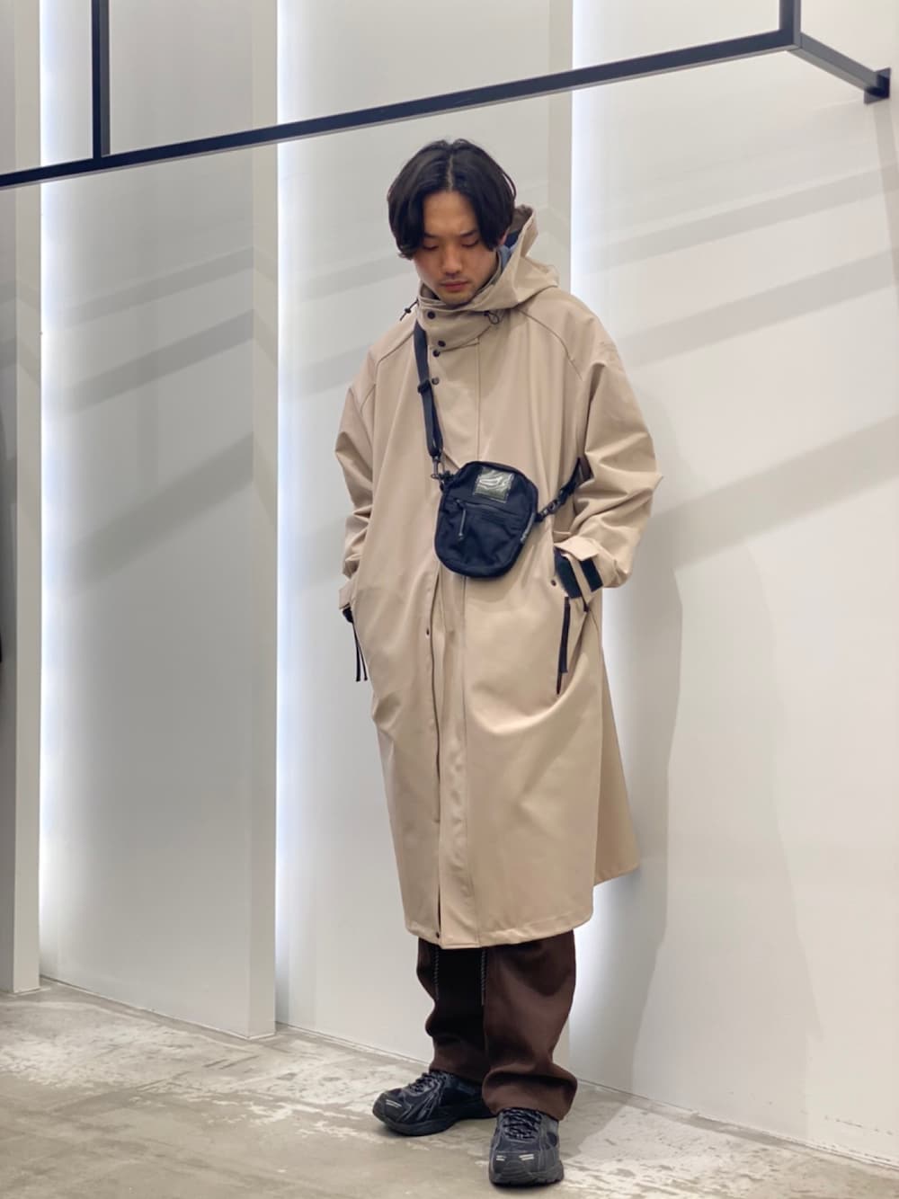 「モッズコート、ショルダーバッグ、ロング丈、ホワイトコーデ、きれいめカジュアル、フレアパンツ、メガネ男子」｜「URBAN RESEARCHのGOODBETTERBEST　モッズコート（モッズコート、ベージュ系）」を使った、新村優樹さん（メンズ・177cm）の冬コーディネートの1枚目の写真