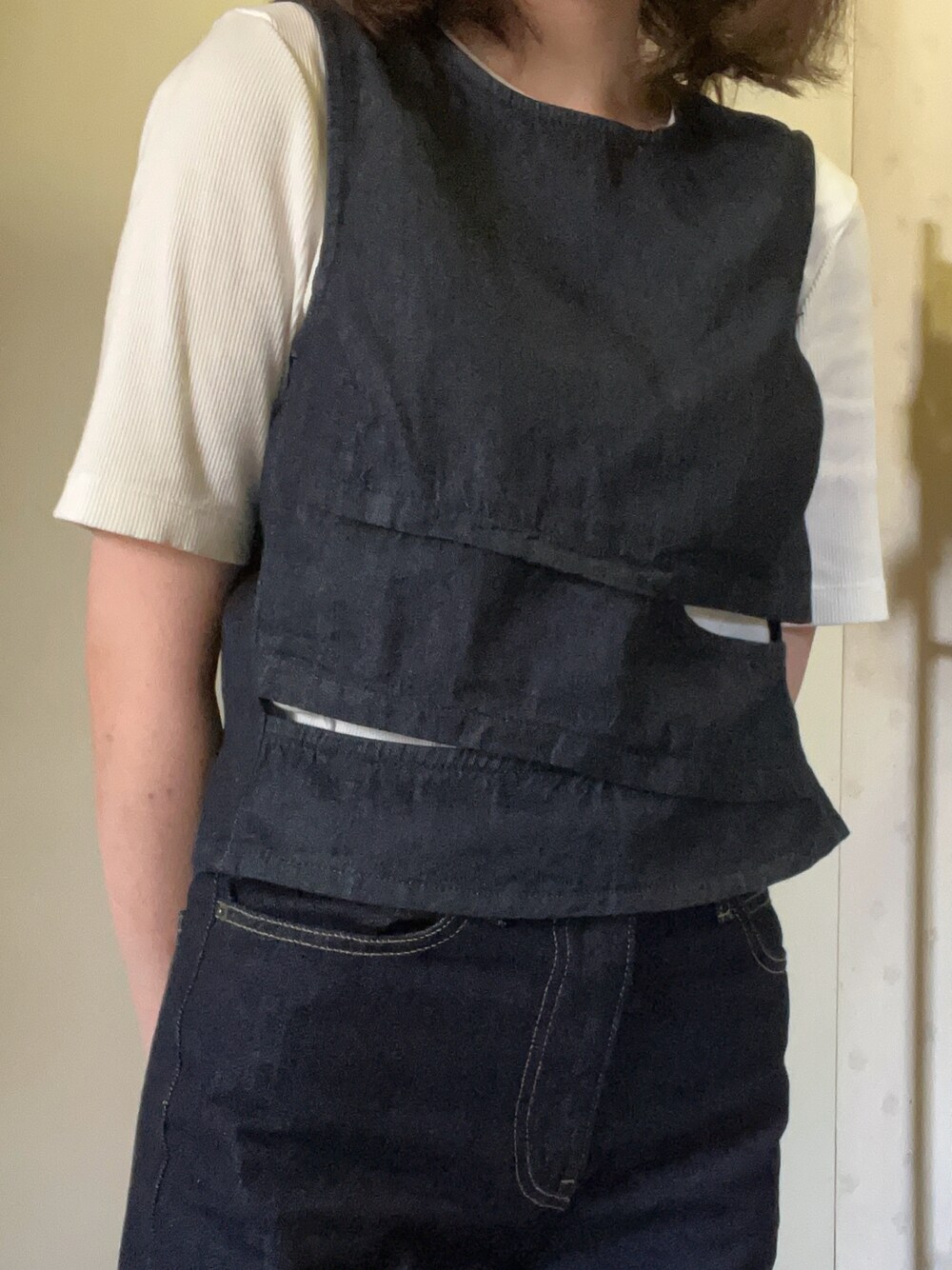 ブルー系のベスト、ホワイト系のTシャツ/カットソー、ブルー系のデニムパンツを着用したレディースの春コーディネートの1枚目の写真