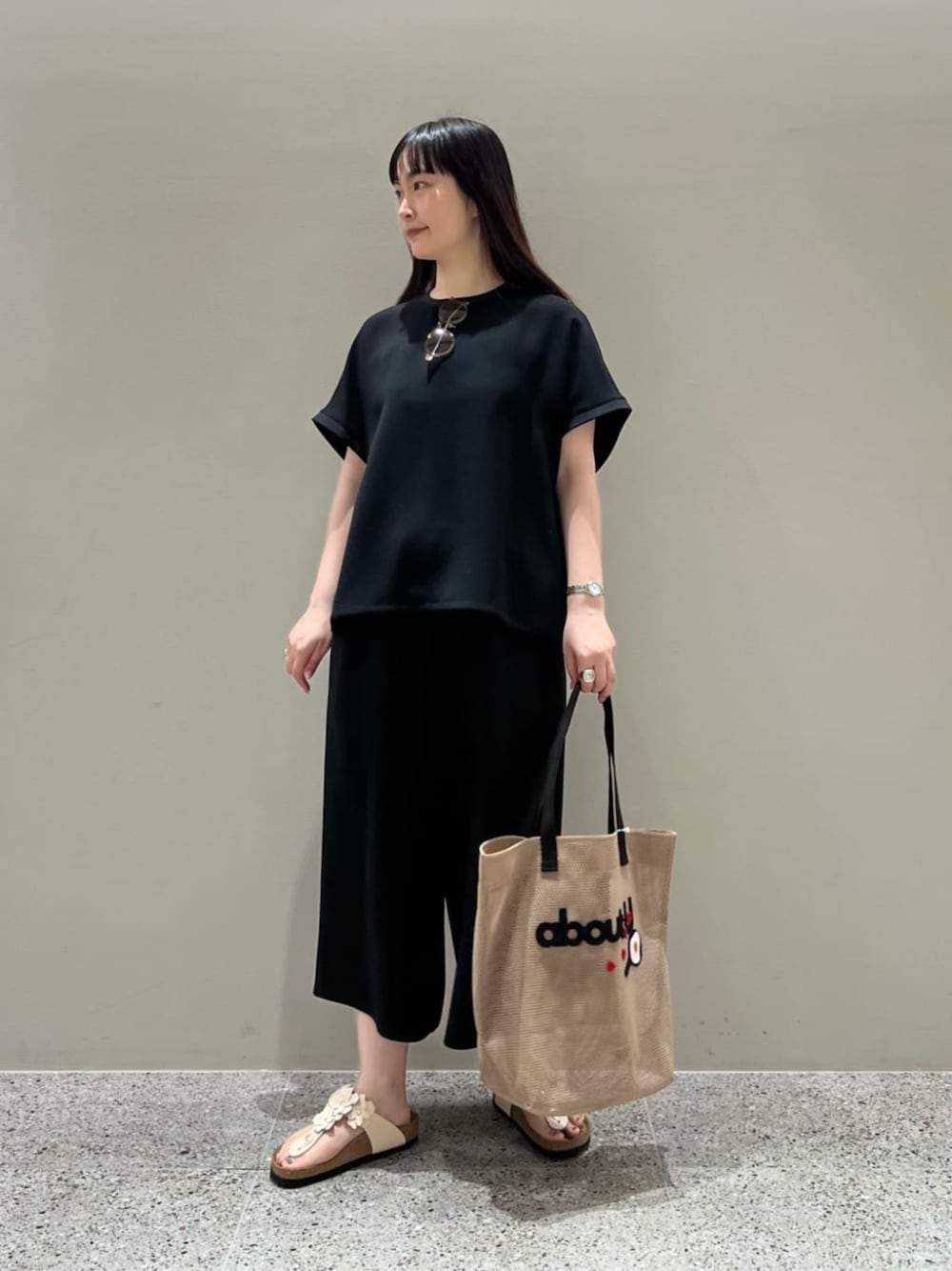 ブラック系のシャツ/ブラウス、ブラック系のスラックス、ピンク系のサンダルを着用したレディースの夏コーディネートの1枚目の写真