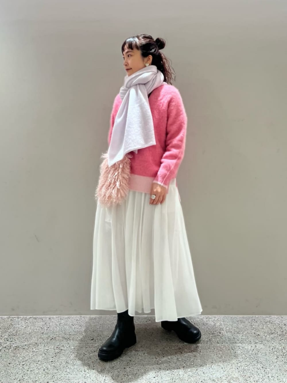 ブラック系のブーツ、その他のニット/セーター、ホワイト系のスカートを着用したレディースの冬コーディネートの1枚目の写真