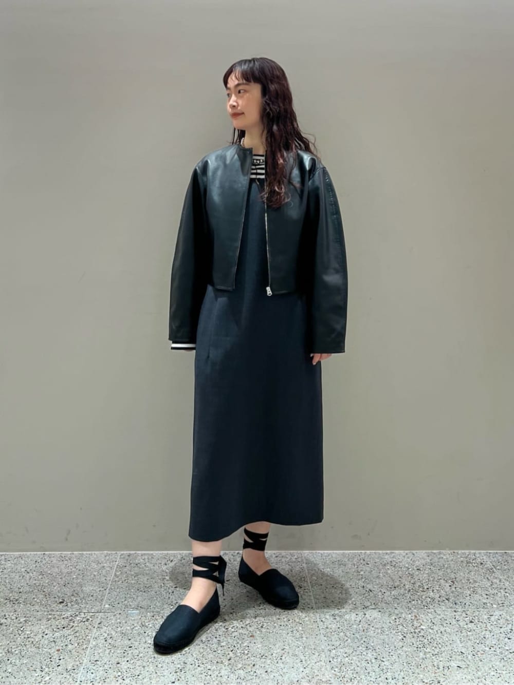 ブラック系のスリッポン、ブラック系のTシャツ/カットソー、グレー系のワンピースを着用したレディースの春コーディネートの1枚目の写真