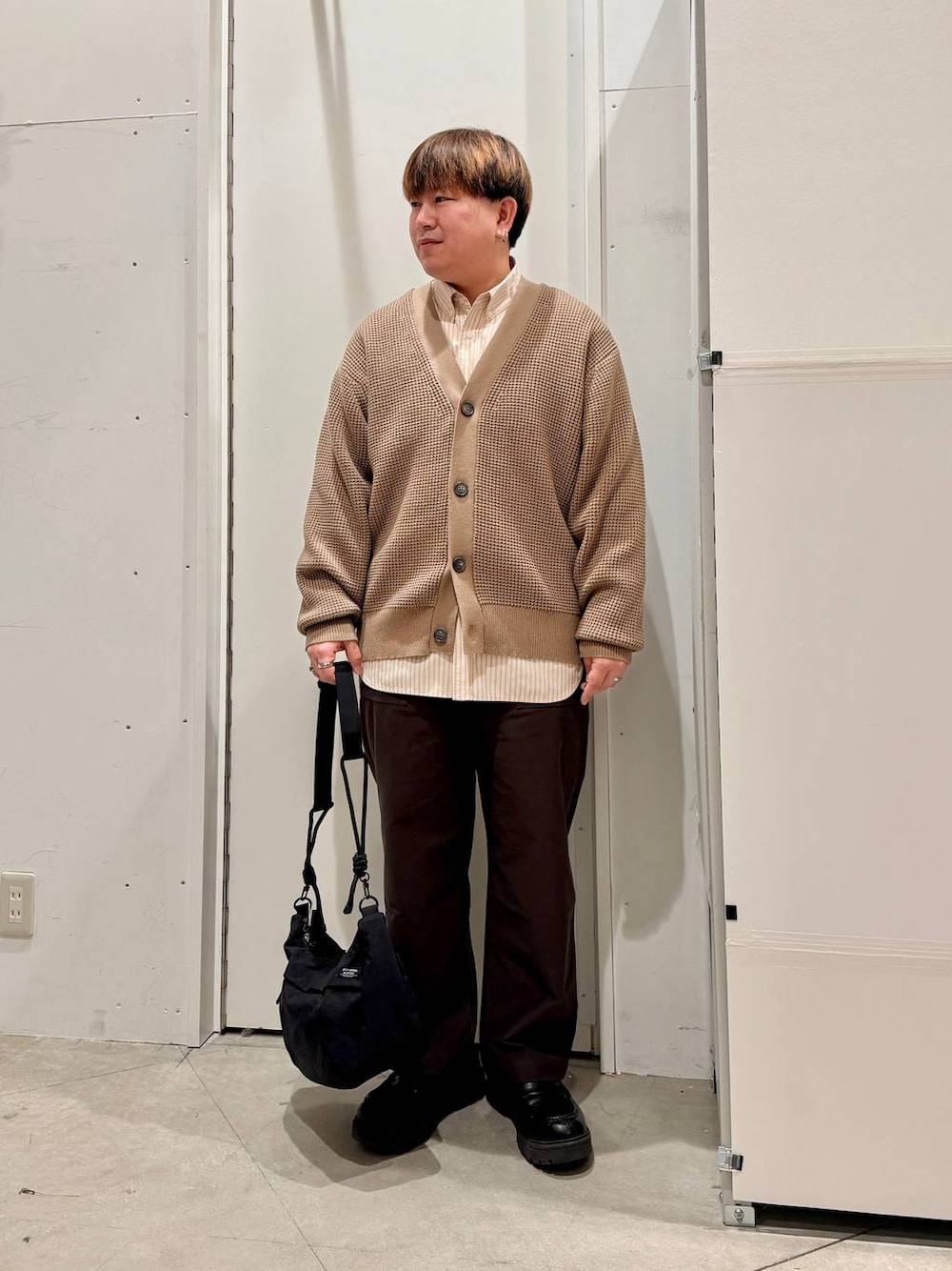 ブラック系のショルダーバッグ、ベージュ系のカーディガン/ボレロ、ベージュ系のシャツ/ブラウスを着用したメンズの冬コーディネートの1枚目の写真