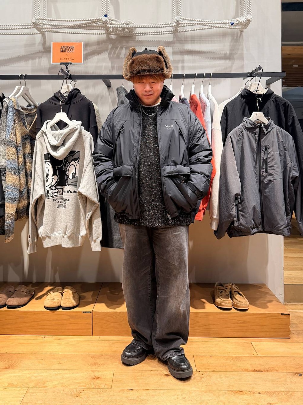 ブラック系のダウンジャケット/コート、ブラック系のデニムパンツ、ブラック系のニット/セーターを着用したメンズの冬コーディネートの1枚目の写真