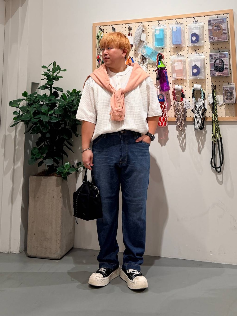ブルー系のデニムパンツ、オレンジ系のシャツ/ブラウス、ブラック系のショルダーバッグを着用したメンズの春コーディネートの1枚目の写真