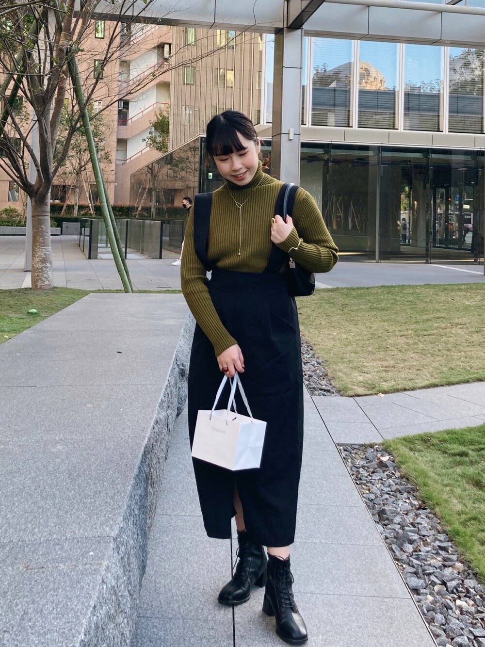 ブラック系のスカートを着用したレディースの春コーディネートの1枚目の写真