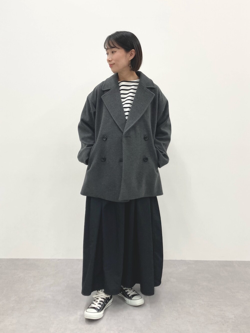 グレー系のダッフルコート、ブルー系のTシャツ/カットソーを着用したレディースの秋コーディネートの1枚目の写真