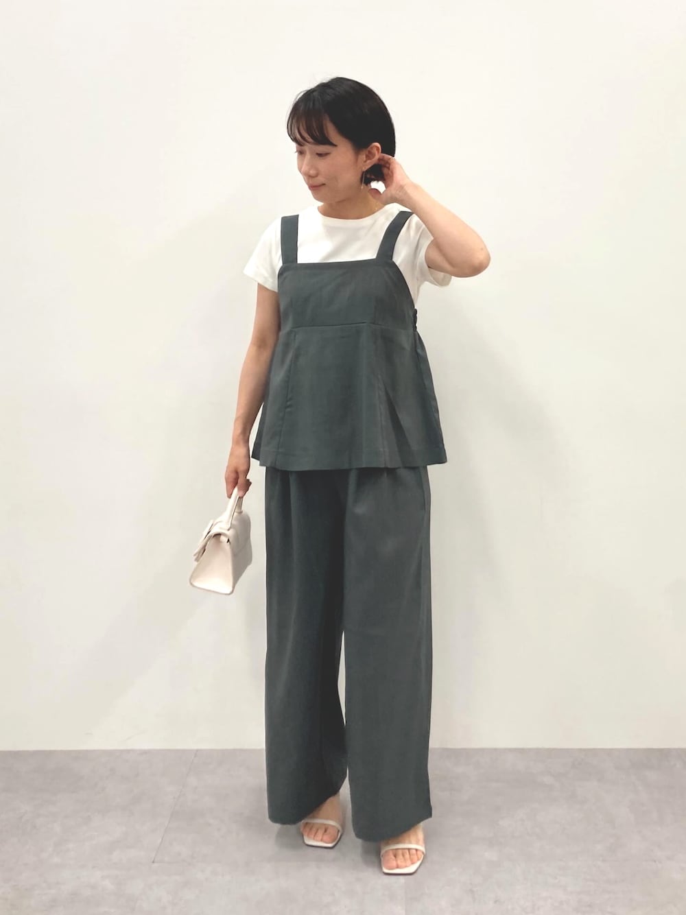 グレー系のパンツを着用したレディースの夏コーディネートの1枚目の写真