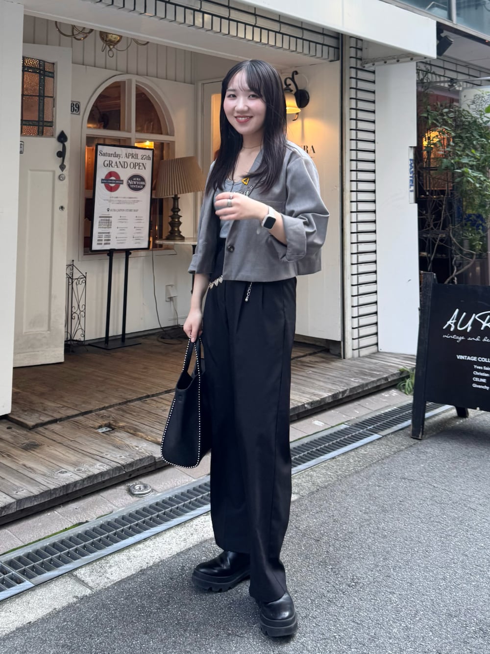 ブラック系のスラックス、ブラック系のブーツ、ブラック系のショルダーバッグを着用したレディースの秋コーディネートの1枚目の写真