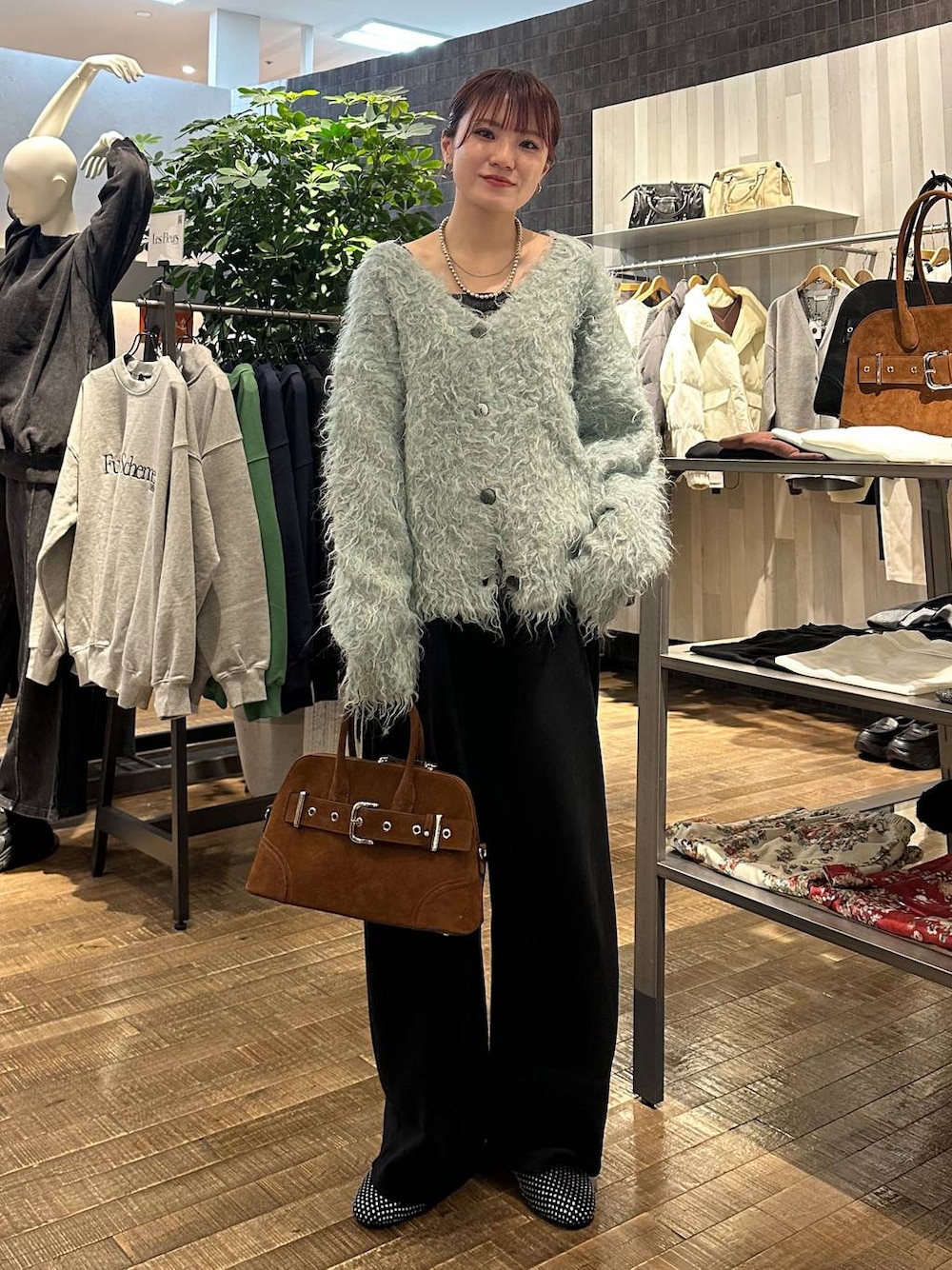 ブラック系のパンプス、ブラウン系のボストンバッグ、ブラック系のスウェットパンツを着用したレディースの冬コーディネートの1枚目の写真