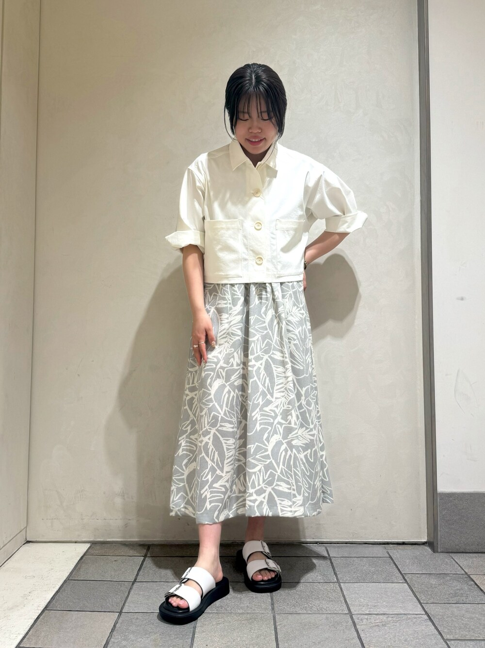 ホワイト系のブルゾン、グレー系のワンピースを着用したレディースの夏コーディネートの1枚目の写真