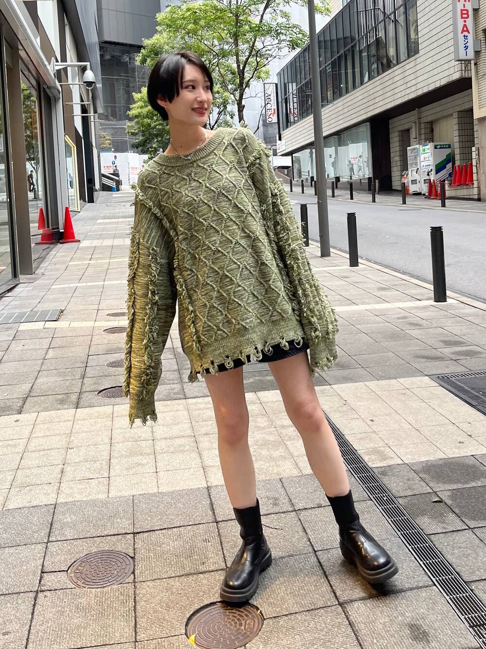 グリーン系のニット/セーターを着用したレディースの冬コーディネートの1枚目の写真