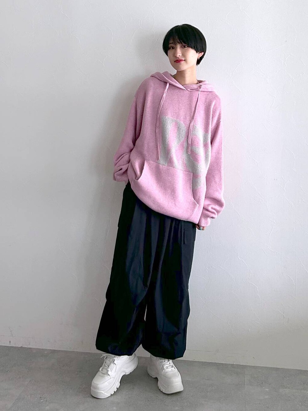 ブラック系のその他パンツ、ピンク系のニット/セーターを着用したレディースの冬コーディネートの1枚目の写真