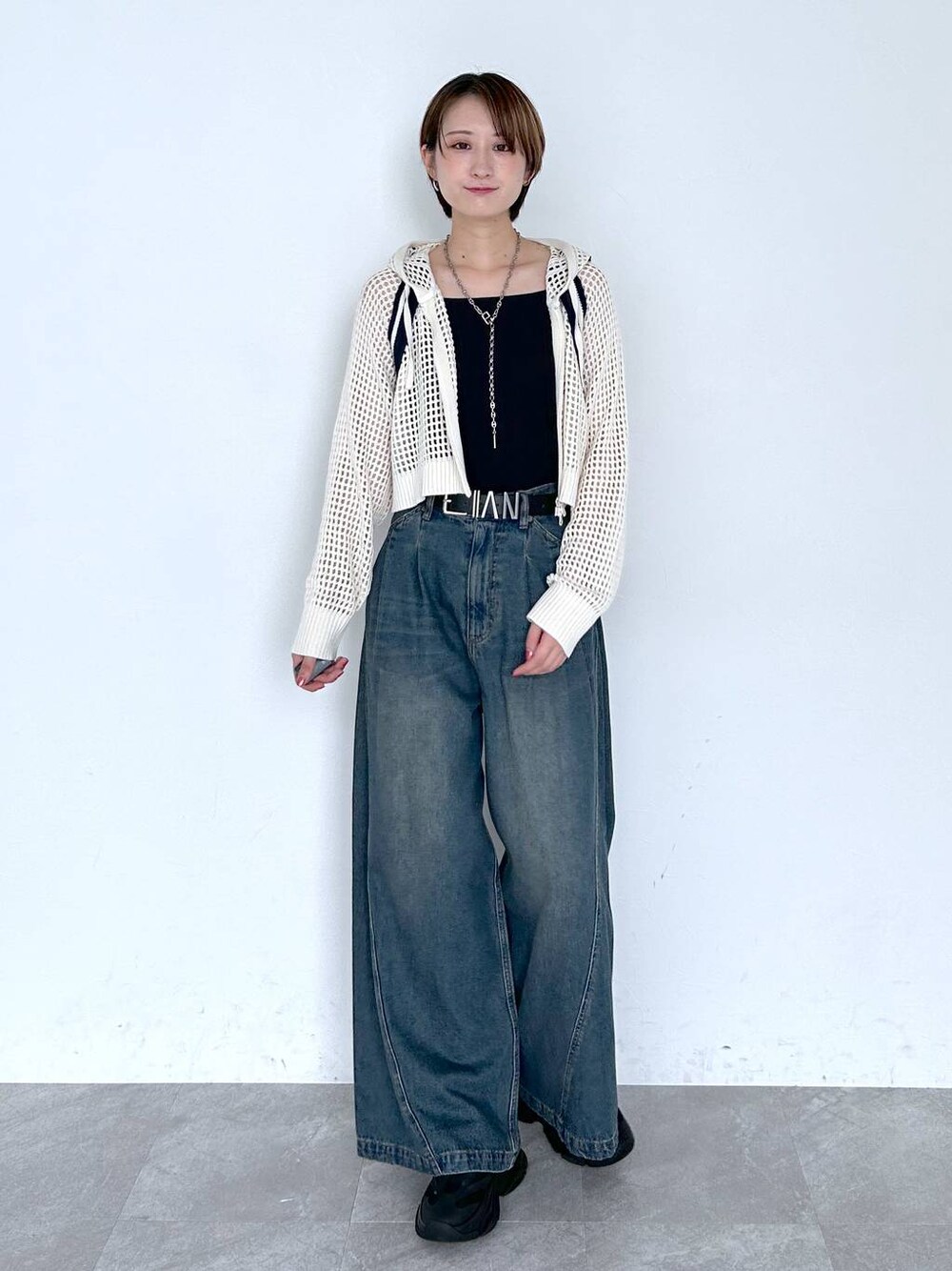 ブルー系のデニムパンツ、ホワイト系のパーカー、ブラック系のベルトを着用したレディースの夏コーディネートの1枚目の写真