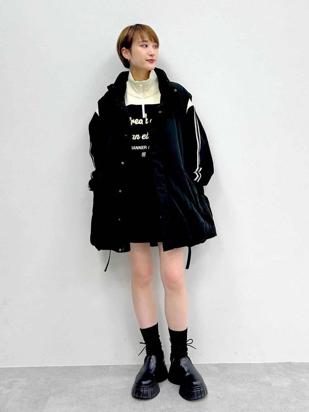 ブラック系のブルゾン、ブラック系のブーツ、ブラック系のスカートを着用したレディースの冬コーディネートの1枚目の写真