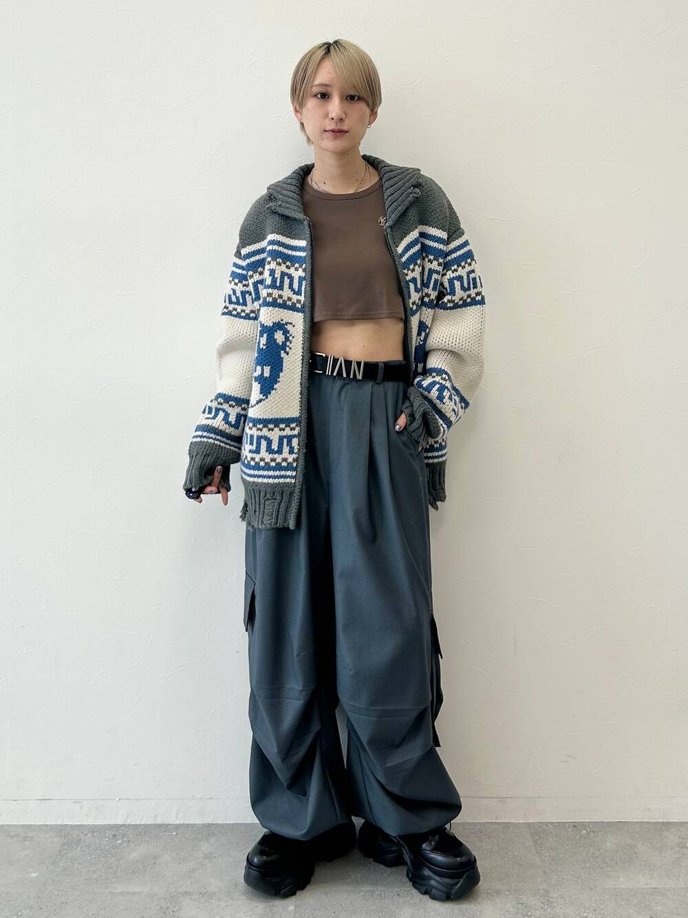 ブラック系のブーツ、ブラウン系のTシャツ/カットソー、グレー系のカーディガン/ボレロを着用したレディースの秋コーディネートの1枚目の写真